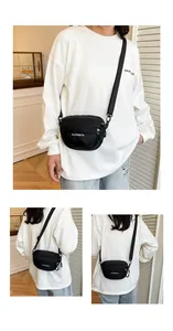 Close-up of a black waterproof nylon crossbody bag with adjustable wide strap on a model