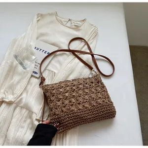 Close-up of intricate hollow floral knit pattern on brown woven tote bag with PU strap