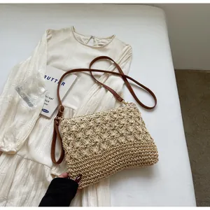 Detailed macro view of woven straw tote bag with delicate leather strap on summer dress
