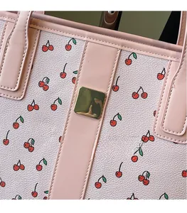 Close-up of pink tote bag showing cherry print and square gold metal hardware detail