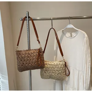 Detail of star-pattern woven tote bag with leather straps and metal hooks in resort style