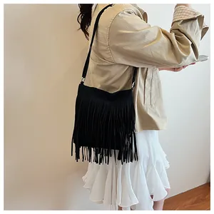 Vue détaillée du sac seau en daim noir avec de longues franges et une fine bandoulière