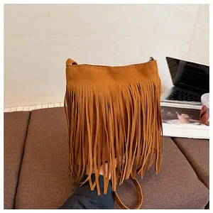 Détail du sac seau en daim caramel avec de longues franges et une fine bandoulière