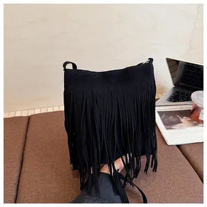 Vue détaillée du sac seau en daim noir avec de longues franges dans un cadre lifestyle