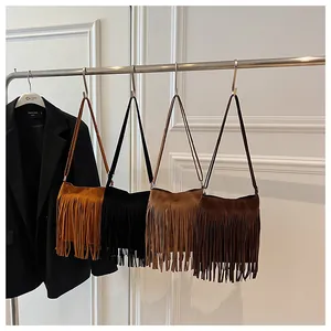 Détail de sacs seaux à franges en daim déclinés en jaune, noir, camel et café