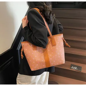 Close-up of brown floral tote bag with ribbon prints on a stylish model outdoors