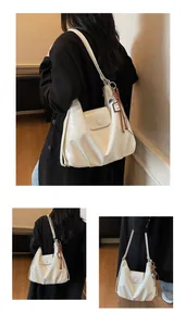 Détail du sac à bandoulière plissé blanc avec rabat et pendentifs de mode élégants