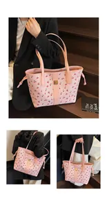 Detailed close-up of pink cherry print tote bag with gold metal plaque and side drawstrings