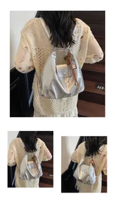 Détail du cuir PU argenté avec fermeture magnétique et pendentif latéral sur le sac à dos