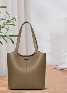 Macro detail of khaki litchi grain leather tote bag featuring elegant brand logo texture