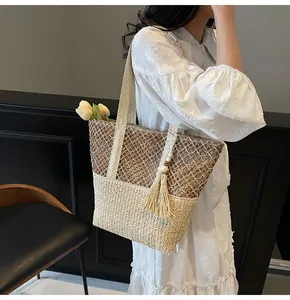 Détail du sac cabas tissé main avec design bicolore en maille et pompon décoratif