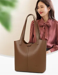 Detail of dark brown lychee leather tote bag with vertical stitching and long handle