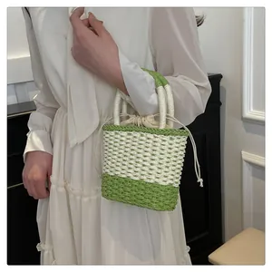 Detail van geweven strooien emmer tas met groen patchwork en voering met trekkoord