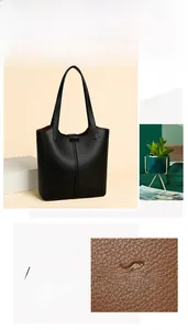 Detail of black pebbled leather texture and embossed logo on minimalist tote bag