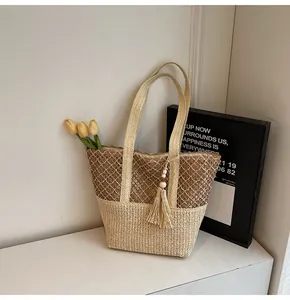 Détail du sac cabas en paille tissé main avec maille et breloque pompon en perles de bois