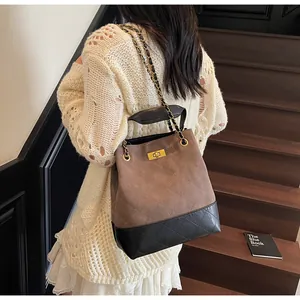 Detail of vintage quilted tote bag featuring chain strap and metallic clasp on model