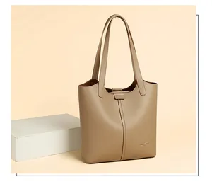 Detail of khaki lychee grain leather tote featuring vertical stitching and double shoulder straps