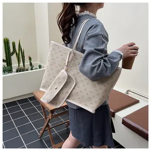 Dettaglio del set borsa tote e mini bag bianco panna con stampa cartoon su modella
