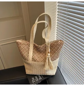 Détail du sac fourre-tout en paille tissé main avec maille évidée et pompon en perles