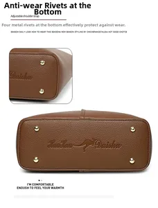 Detailed view of brown tote bag bottom with gold rivets and lychee grain texture