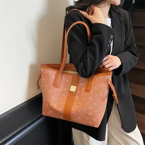 Brown leather tote bag with pink bow floral print shown on a model's shoulder
