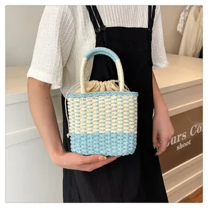 Detail van de handgeweven strooien crossbodytas met lichtblauwe accenten en voering