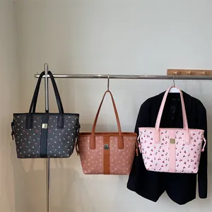 Three patterned tote bags in black, brown and pink with cherry and bow prints
