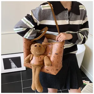 Dettaglio della borsa tote marrone con stampe di orsetti e ciondolo orsetto di peluche
