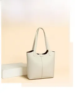 Detail of lychee pattern leather texture and vertical stitching on cream tote bag