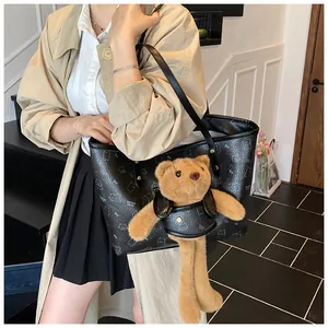 Dettaglio della borsa tote con stampa orsetto, ciondolo in peluche e tracolla in pelle nera