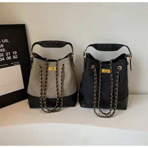Detail of quilted leather tote bags with chain straps and gold hardware closures