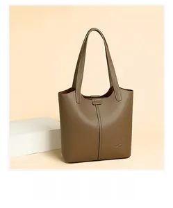 Detail of brown lychee grain leather tote bag with stitching and gold logo accent