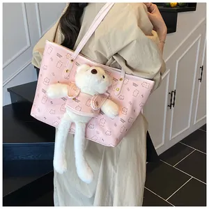 Dettaglio della borsa rosa con stampa di orsetto e ciondolo di peluche bianco morbido