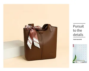 Detail of brown lychee grain leather tote bag featuring elegant printed silk scarf handle