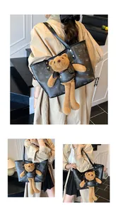 Dettaglio della borsa tote in pelle nera con stampe di orsi e ciondolo orsetto di peluche