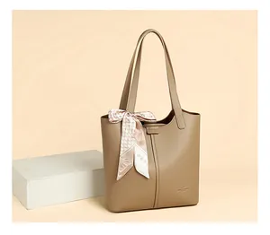 Close-up of khaki lychee leather tote bag with elegant floral scarf on the handle