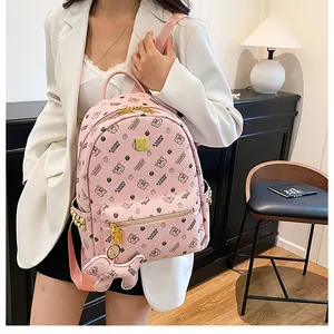 Détail d'un sac à dos rose avec motifs d'ours, fermetures dorées et pendentif ours