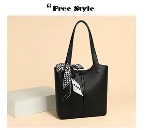 Detail of black litchi grain leather tote bag with decorative polka dot silk scarf