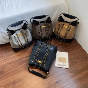 Quilted tote bucket bags in four colors with chain straps on wooden floor
