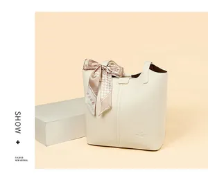 Close-up of cream leather tote bag featuring kangaroo logo and decorative floral silk scarf