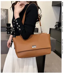 Close-up of caramel brown lychee pattern leather shoulder bag with silver twist lock
