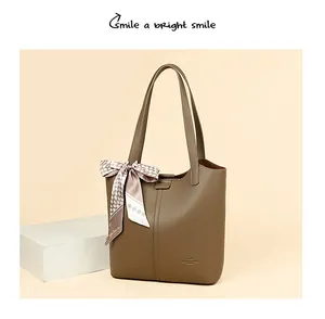 Detailed macro view of the lychee texture leather and logo on this brown tote bag