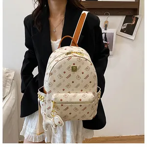 Détail du sac à dos imprimé avec fermeture dorée, logo en métal et pendentif ours