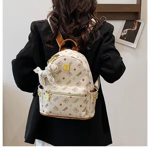 Détail du sac à dos crème avec imprimés ours, rivets dorés et charm peluche chien