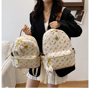 Vue détaillée des sacs à dos à motifs avec pendentifs ours et rivets métalliques