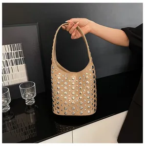 Detailaufnahme der khakifarbenen Ledertasche mit dekorativen silbernen Metallnieten