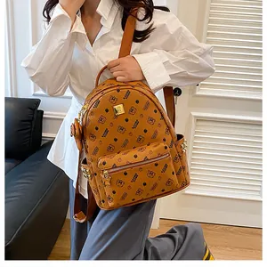Détail d'un sac à dos en cuir marron avec imprimé monogramme et clous dorés sur le côté