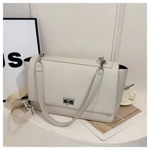 Detail of cream white pebbled leather bag featuring a silver twist-lock and wide strap