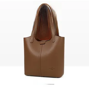 Close-up of brown lychee grain leather tote bag with vertical stitching and logo details