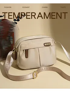Detail of waterproof oxford crossbody bag with adjustable wide shoulder strap and gold hardware